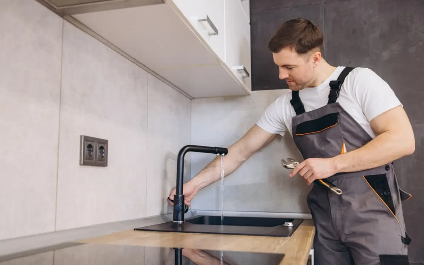 Specialist testing a kitchen tap during a fit-out. Illustrative photograph.